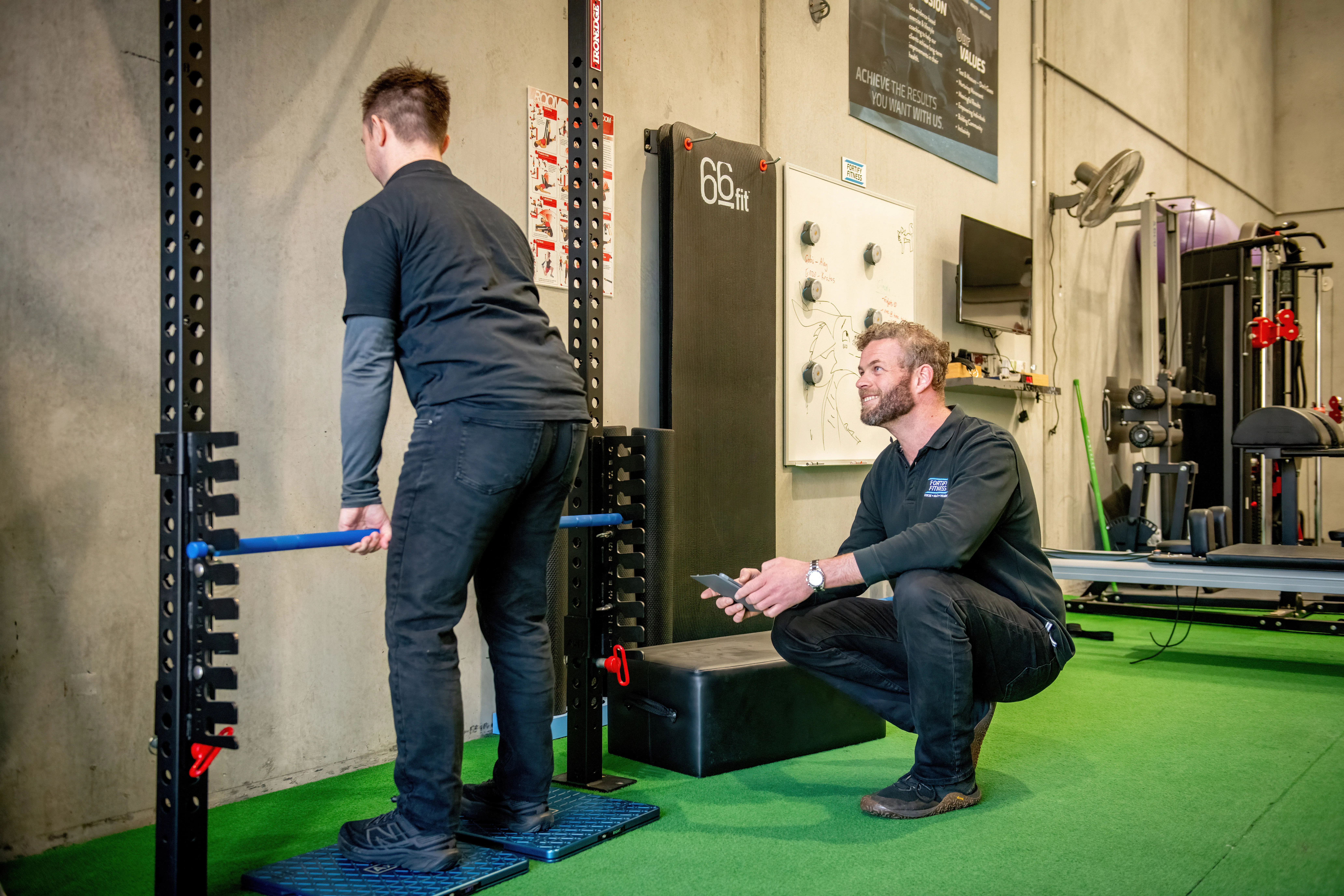 Fortify coach guiding a client through a strength exercise